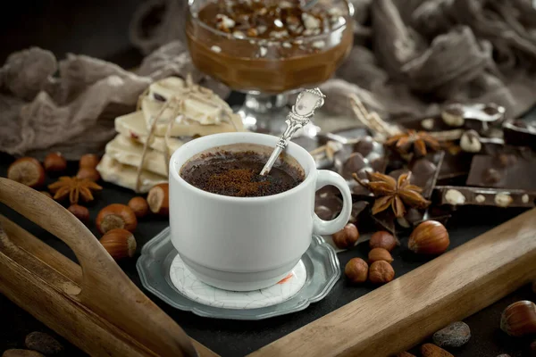 Eskimiş bir arka planda kakao çekirdeği ve fındıklı siyah çikolata..