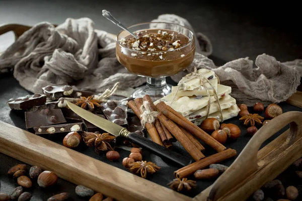 Eskimiş bir arka planda kakao çekirdeği ve fındıklı siyah çikolata..