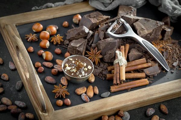 Eskimiş bir arka planda kakao çekirdeği ve fındıklı siyah çikolata..