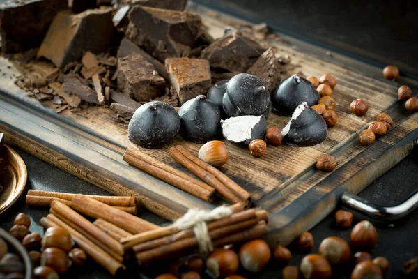 Eskimiş bir arka planda kakao çekirdeği ve fındıklı siyah çikolata..