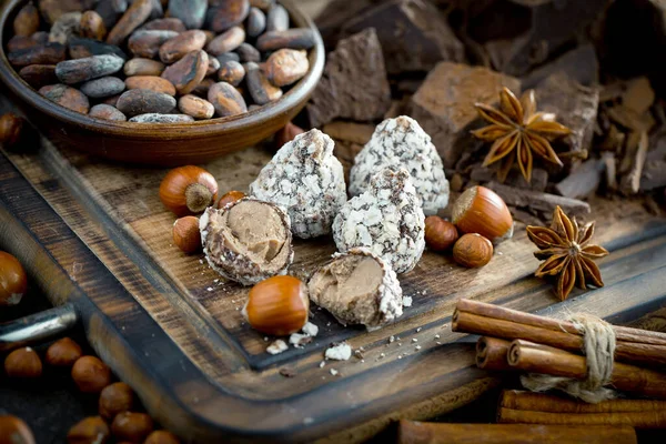 Eskimiş bir arka planda kakao çekirdeği ve fındıklı siyah çikolata..