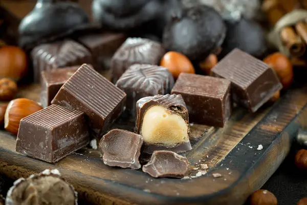 Kakao çekirdeğinin arka planında koyu çikolata ve mutfak malzemeleri.