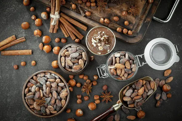 Kakao çekirdeğinin arka planında koyu çikolata ve mutfak malzemeleri.