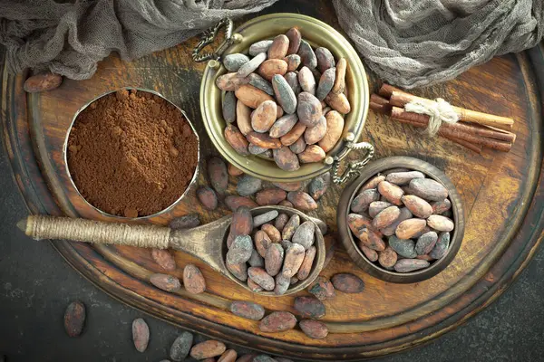 Kakao çekirdeğinin arka planında koyu çikolata ve mutfak malzemeleri.