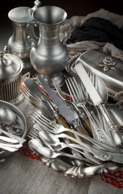 Eski bir arkaplanda gümüş eşyalar.