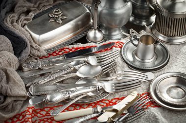 Eski bir arkaplanda gümüş eşyalar.