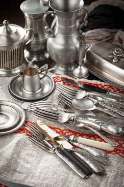 Eski bir arkaplanda gümüş eşyalar.