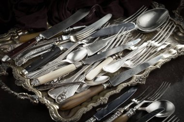 Eski bir arkaplanda gümüş eşyalar.