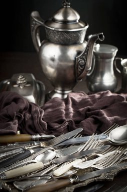 Eski bir arkaplanda gümüş eşyalar.