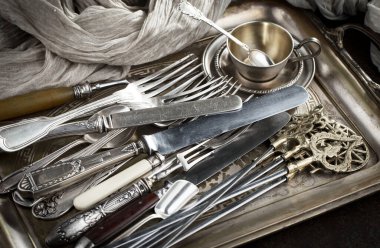 Eski bir arkaplanda gümüş eşyalar.