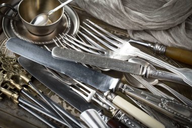 Eski bir arkaplanda gümüş eşyalar.