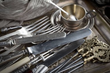 Eski bir arkaplanda gümüş eşyalar.