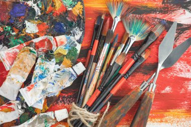 Eski bir arkaplanda resim yapmak için fırçalar ve boyalar.