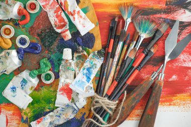 Eski bir arkaplanda resim yapmak için fırçalar ve boyalar.
