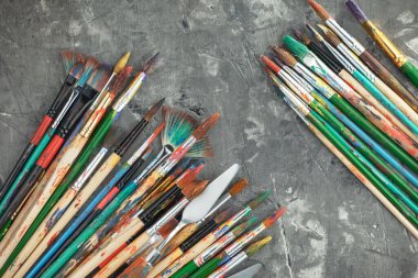 Eski bir arkaplanda resim yapmak için fırçalar ve boyalar.