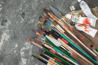 Eski bir arkaplanda resim yapmak için fırçalar ve boyalar.