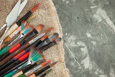 Eski bir arkaplanda resim yapmak için fırçalar ve boyalar.