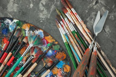 Eski bir arkaplanda resim yapmak için fırçalar ve boyalar.