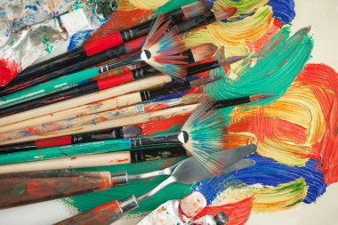 Eski bir arkaplanda resim yapmak için fırçalar ve boyalar.