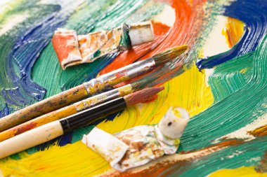 Eski bir arkaplanda resim yapmak için fırçalar ve boyalar.