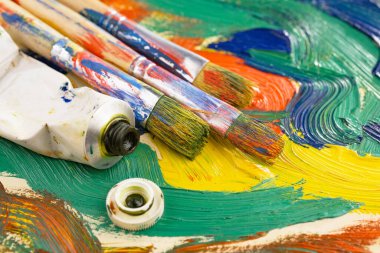 Eski bir arkaplanda resim yapmak için fırçalar ve boyalar.
