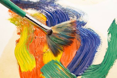 Tüpten çıkartılan çok renkli yağlı boyalar beyaz bir kağıt parçasına sıkıştı..