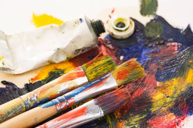 Tüpten çıkartılan çok renkli yağlı boyalar beyaz bir kağıt parçasına sıkıştı..