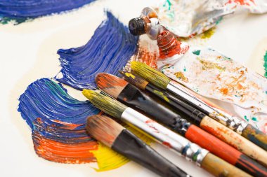 Tüpten çıkartılan çok renkli yağlı boyalar beyaz bir kağıt parçasına sıkıştı..