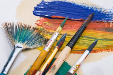 Tüpten çıkartılan çok renkli yağlı boyalar beyaz bir kağıt parçasına sıkıştı..