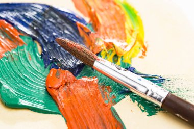 Tüpten çıkartılan çok renkli yağlı boyalar beyaz bir kağıt parçasına sıkıştı..