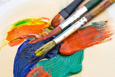 Tüpten çıkartılan çok renkli yağlı boyalar beyaz bir kağıt parçasına sıkıştı..