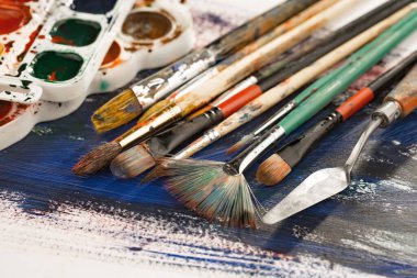 Tüpten çıkartılan çok renkli yağlı boyalar beyaz bir kağıt parçasına sıkıştı..