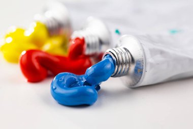 Tüpten çıkartılan çok renkli yağlı boyalar beyaz bir kağıt parçasına sıkıştı..