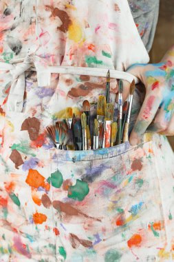 Sanatçının kadın elleri, çizim için fırçalar ve boyalar..