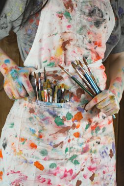 Sanatçının kadın elleri, çizim için fırçalar ve boyalar..