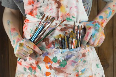 Sanatçının kadın elleri, çizim için fırçalar ve boyalar..