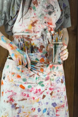 Sanatçının kadın elleri, çizim için fırçalar ve boyalar..