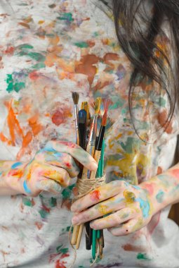Sanatçının kadın elleri, çizim için fırçalar ve boyalar..