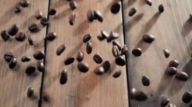 Kavrulmuş kahve çekirdekleri yavaşça tabağa düşüyor.