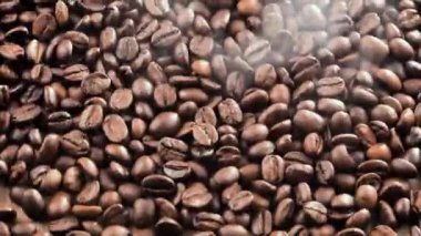 Kavrulmuş kahve çekirdekleri tahtada yavaşça zıplıyor.