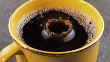 Bir damla yavaşça kahveye düşer.