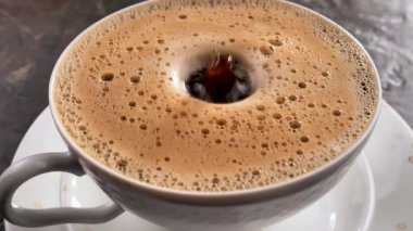 Bir damla yavaşça kahveye düşer.