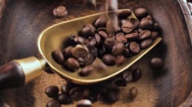 Kavrulmuş kahve çekirdekleri yavaşça tabağa düşüyor.