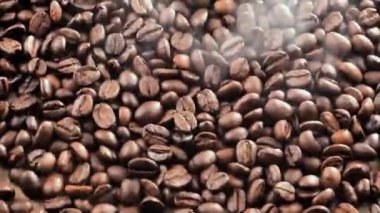 Kavrulmuş kahve çekirdekleri tahtada yavaşça zıplıyor.