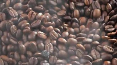 Kavrulmuş kahve çekirdekleri kahve öğütücüsünde yavaşça döner.