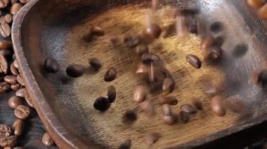 Kavrulmuş kahve çekirdekleri yavaşça tabağa düşüyor.