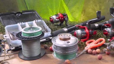 Stüdyoda bir masada bulunan spor balıkçılığı ekipmanları, bir ağın arka planına karşı bir kompozisyon..