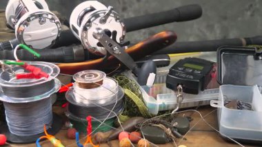 Stüdyoda bir masada bulunan spor balıkçılığı ekipmanları, bir ağın arka planına karşı bir kompozisyon..