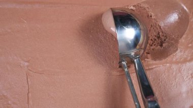 Çikolatalı dondurma topları yavaşça kaşığa konur ve konteynırdan çıkarılır..