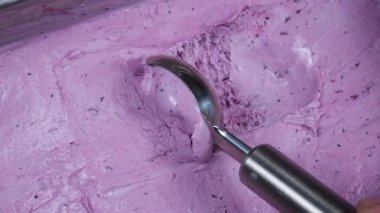 Meyveli dondurma topları yavaşça kaşığa konur ve kabından çıkarılır..